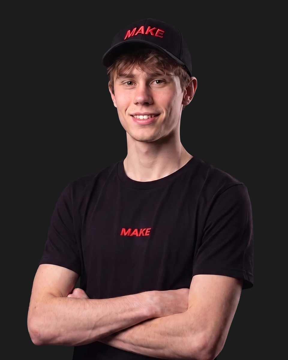 Simon mit schwarzem MAKE-Shirt vor grauem Studiohintergrund.