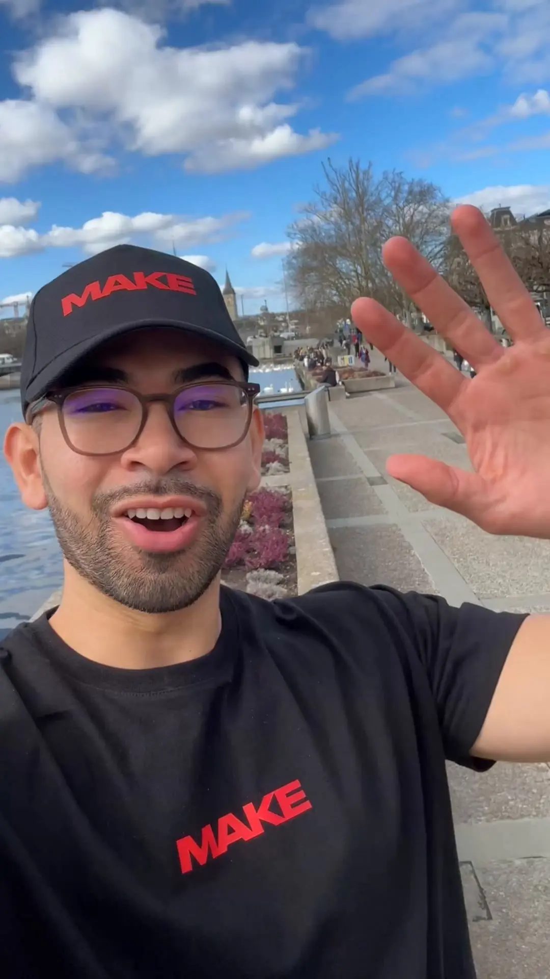 Standbild aus der Video-Anzeige von MAKE: Sprecher mit MAKE-Kappe am Rhein, winkt in die Kamera