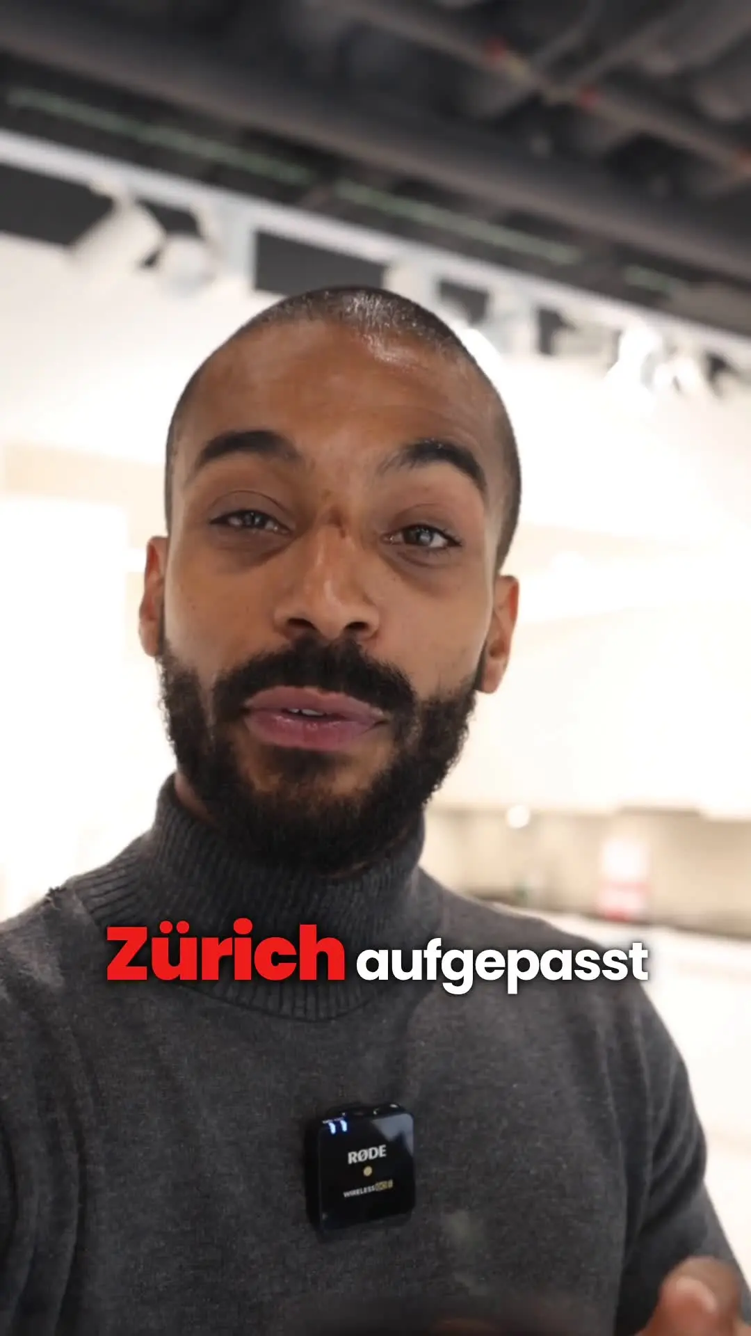 Standbild aus der Video-Anzeige von MGI Design: Sprecher im Showroom, Einblendung Zürich aufgepasst