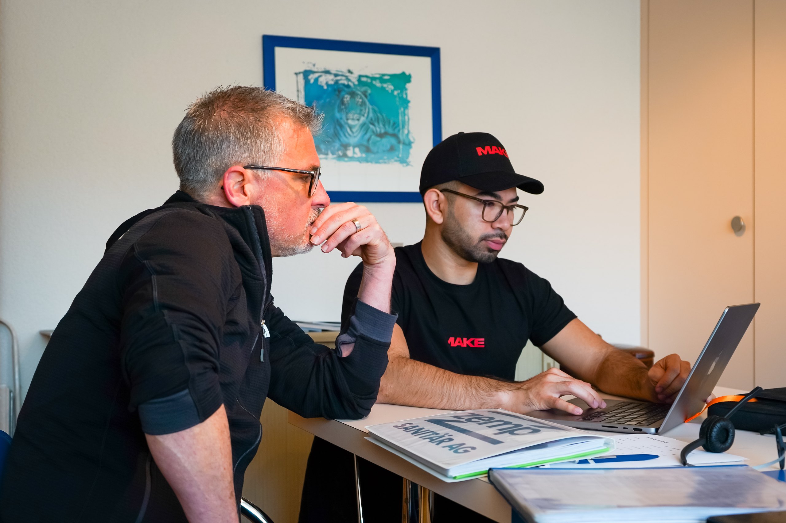 Zwei Männer besprechen einen Entwurf am Laptop