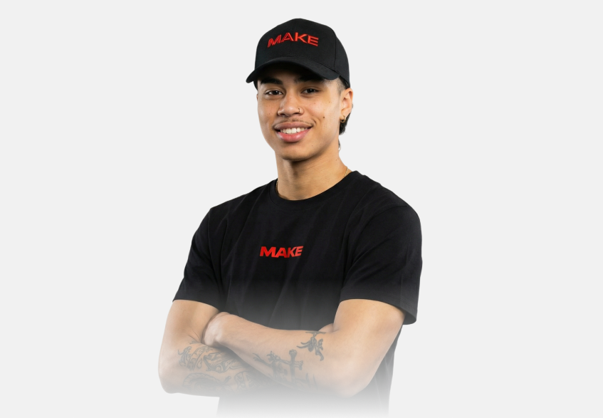 Adrienne Navarro in schwarzer Kappe und T-Shirt mit MAKE-Logo, Arme verschränkt.