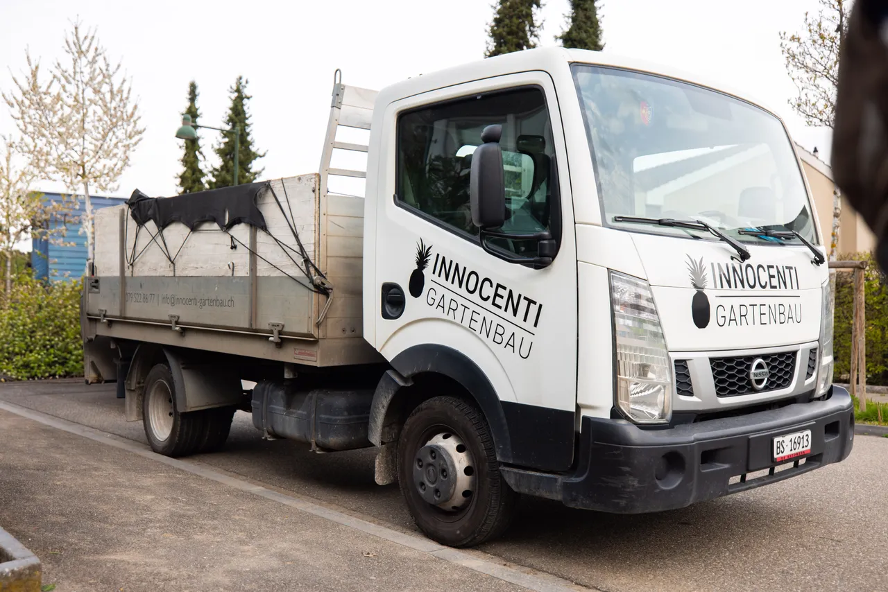 Weisser Pritschenwagen mit Ananas-Logo von Innocenti Gartenbau