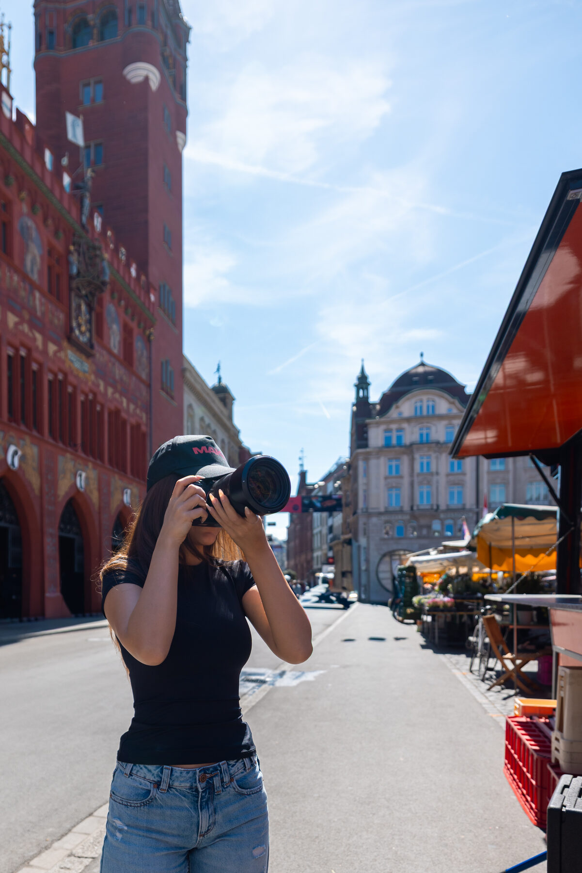 Adrienne Navarro fotografiert mit der Kamera vor dem Basler Rathaus