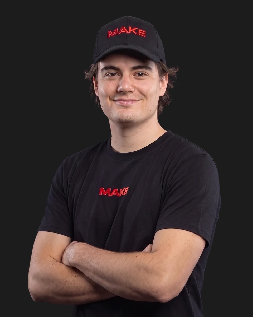 Paul mit schwarzem MAKE-Shirt vor grauem Studiohintergrund.